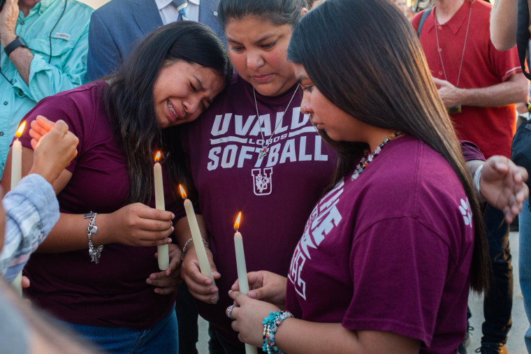 People comfort each other following a vigil held at the Uvalde County Fairplex in Uvalde, Texas, on May 25, 2022.