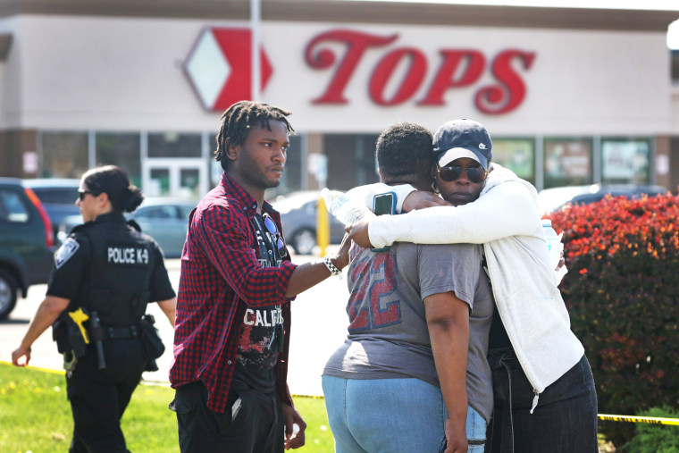 People hug outside of Tops Friendly Market