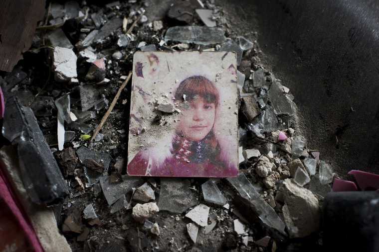 A damaged photograph in a destroyed residential building.