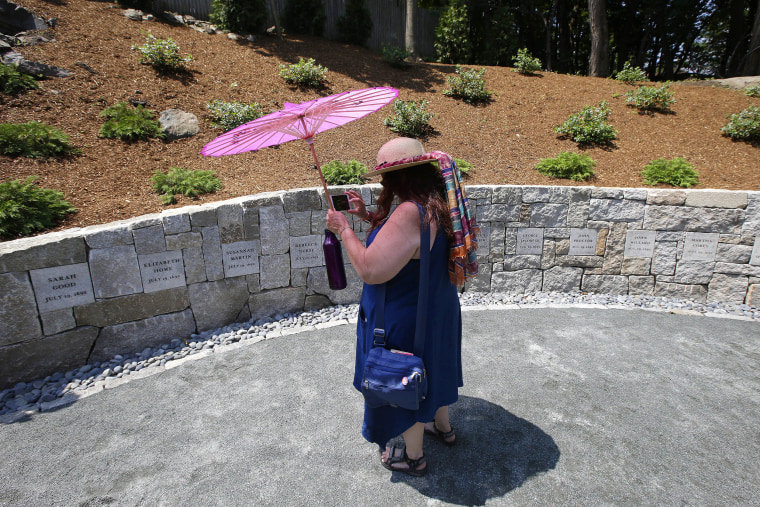 Karla Hailer, a fifth grade teacher from Situate, Mass., makes a video of the Proctor's Ledge Memorial in Salem., Mass., in July 2017.