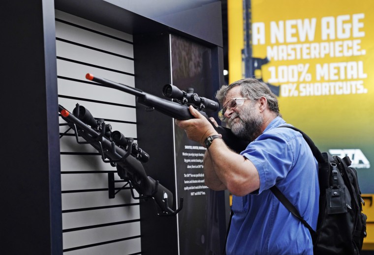 A visitor checks out a rifle at the annual meeting Friday. 