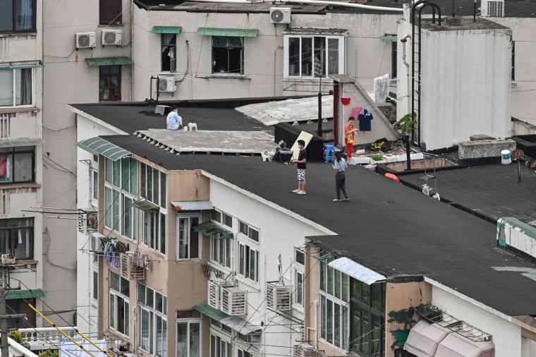 People stand on a rooftop of a building