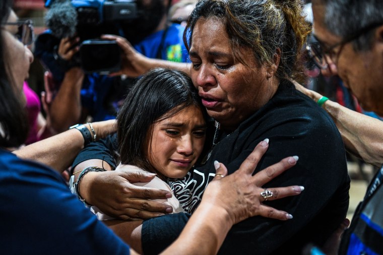 Image: A woman hugs a girl as they cry during a vigil for the victims of the mass shooting at Robb Elementary School in Uvalde, Texas, on May 25, 2022.