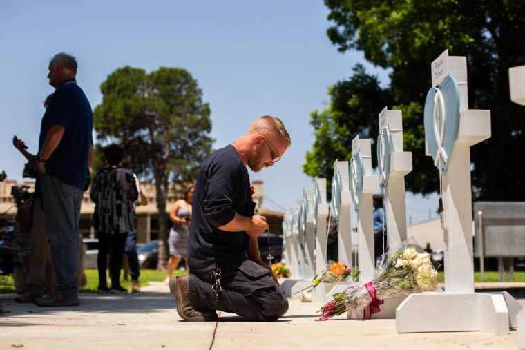 A man prays at a memorial for victims of the May 24th mass shooting at Robb Elementary School