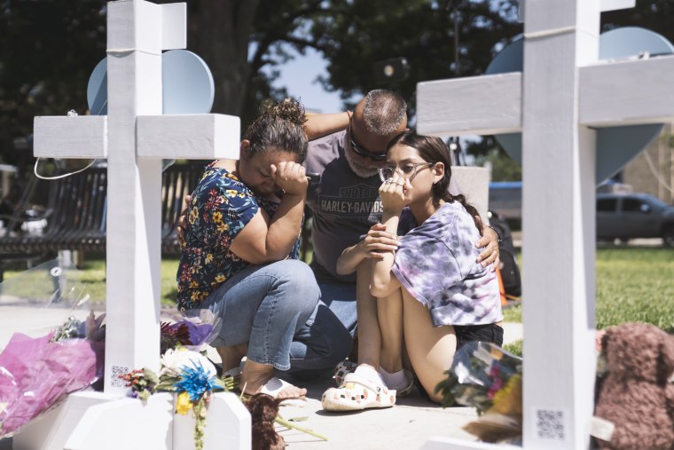 People visit a memorial for victims of the mass shooting at Robb Elementary School