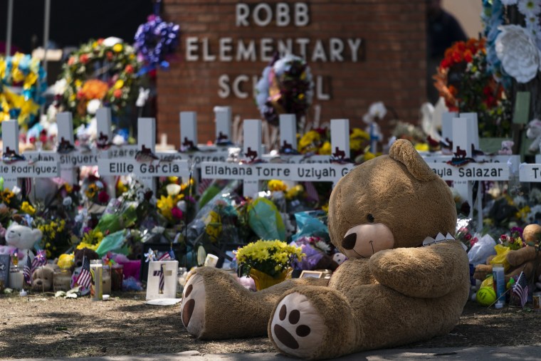 A large teddy bear is placed at a memorial in front of crosses bearing the names of the victims killed in this week's school shooting in Uvalde, Texas Saturday, May 28, 2022.