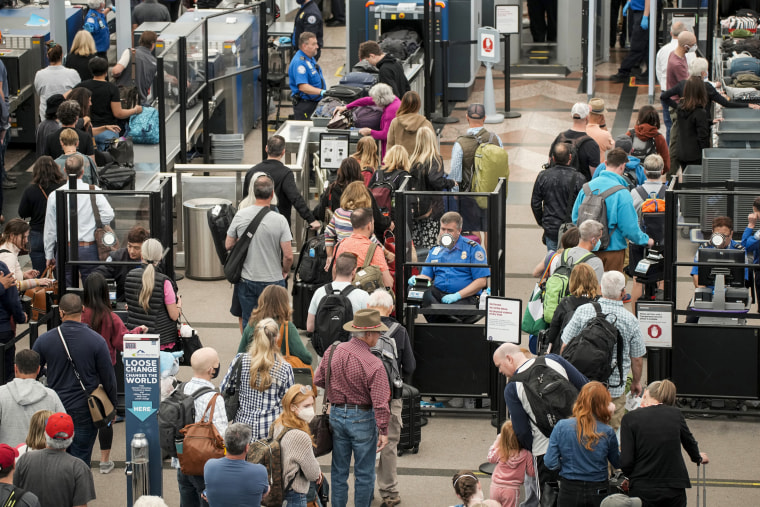 Travelers move through the north security checkpoint in the main terminal of Denver International Airport on May 26, 2022, in Denver.