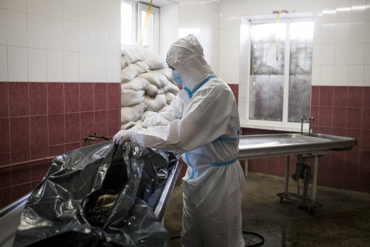 A worker closes a body bag following an examination of the remains of Volodymyr Kotenko at a morgue in Kharkiv last week.