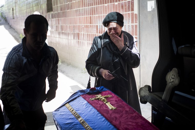 Olga Kotenko cries as a coffin containing the remains of her son, Volodymyr, is loaded into a van outside a morgue in Kharkiv last week. 