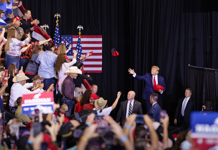 Former President Donald Trump tosses red MAGA hats to the crowd during a rally May 28, 2022 at the Ford Event Center in Casper, Wyo.