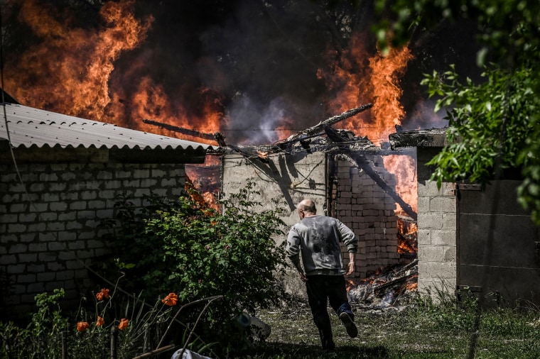 A man walks away from a burning house garage after shelling in the city of Lysytsansk in the eastern Ukrainian region of Donbas on May 30, 2022.