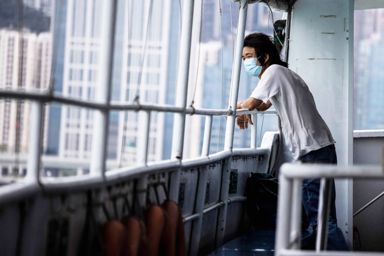 Een man kijkt uit vanaf een veerboot in Hong Kong