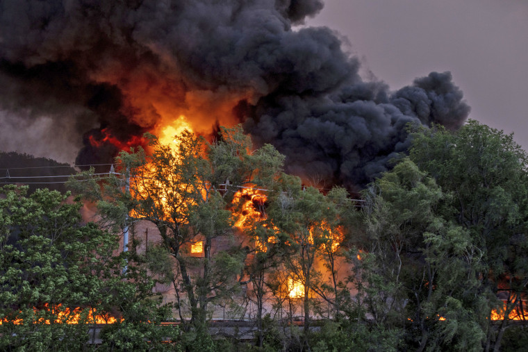 Flames shoot up at the scene of a three-alarm fire at Nox-Crete, Inc., in Omaha, Neb., on May 30, 2022.
