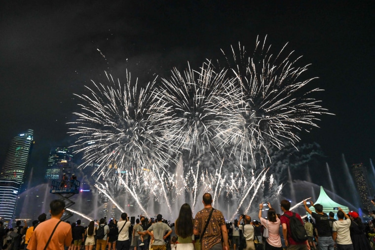 People watch the "Spectra" light and water show