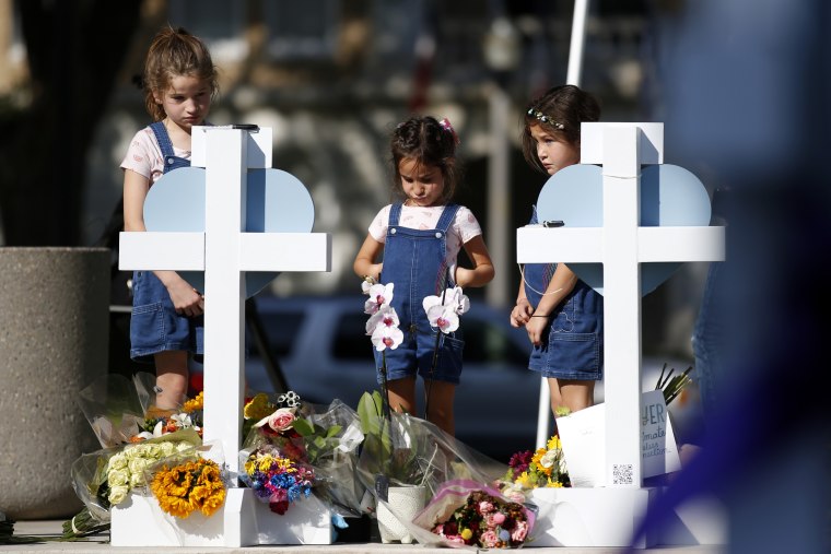 Tres niñas visitan un sitio conmemorativo para las víctimas muertas en el tiroteo de la escuela primaria el jueves 26 de mayo de 2022.