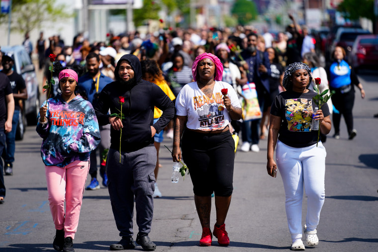 La gente marcha hacia la escena del tiroteo en un supermercado en Buffalo, Nueva York, el domingo 15 de mayo de 2022.