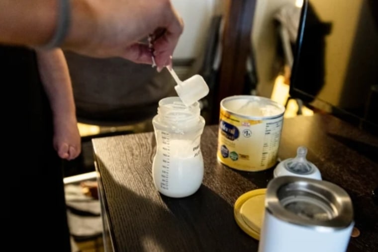 Lisa Davis mezcla un biberón de fórmula para su hijo de 14 meses, Jack, en una habitación de hotel en Austin, Texas.