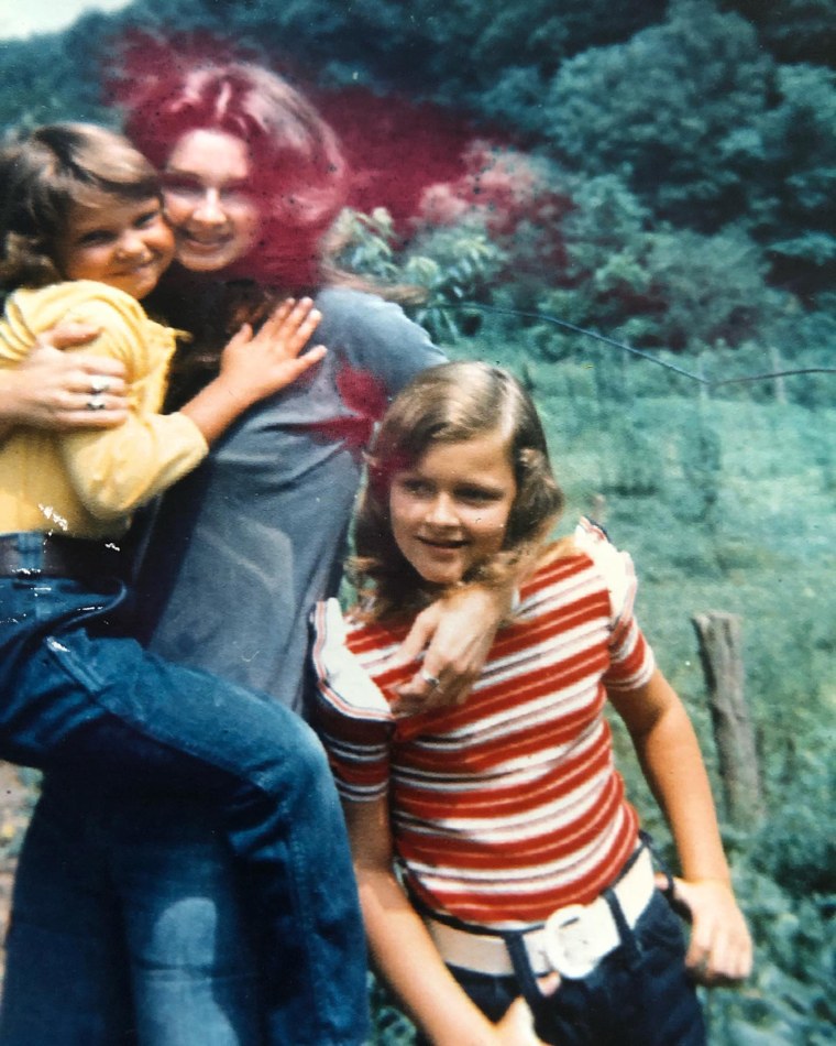 Naomi Judd holds Ashley while Wynonna stands close by in this old photo Ashley shared.