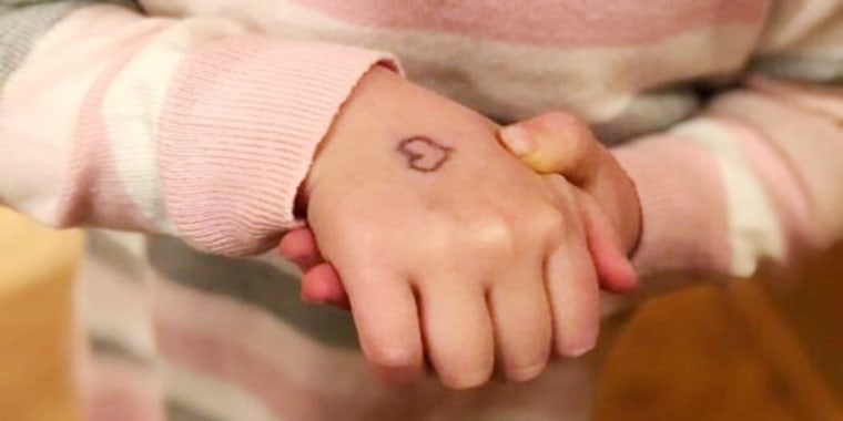 Each morning, Emily Solberg draws a heart on her kids' hands.