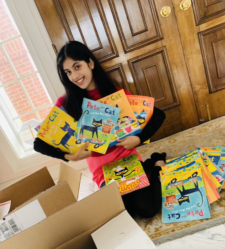 Zuri poses with books to be donated.