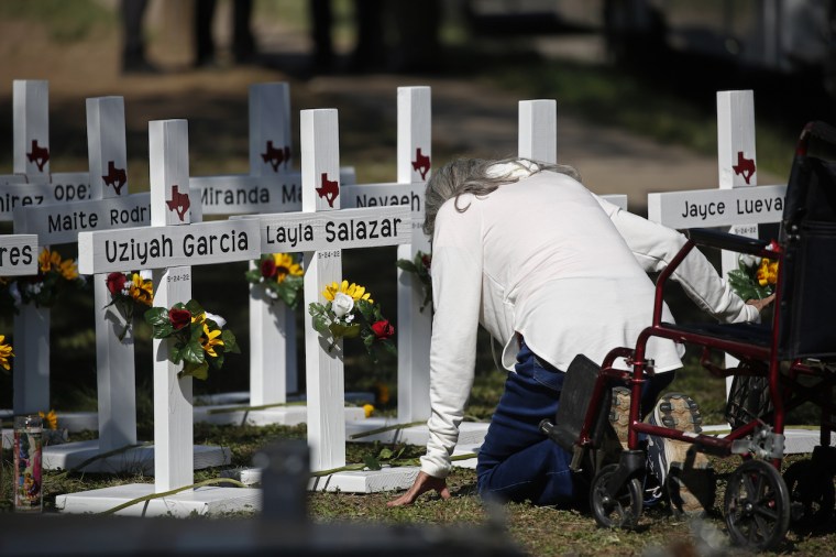 Una mujer se arrodilla frente a las cruces con los nombres de las víctimas de la masacre, afuera de la escuela primaria Robb, en Uvalde, Texas, el jueves 26 de mayo del 2022.