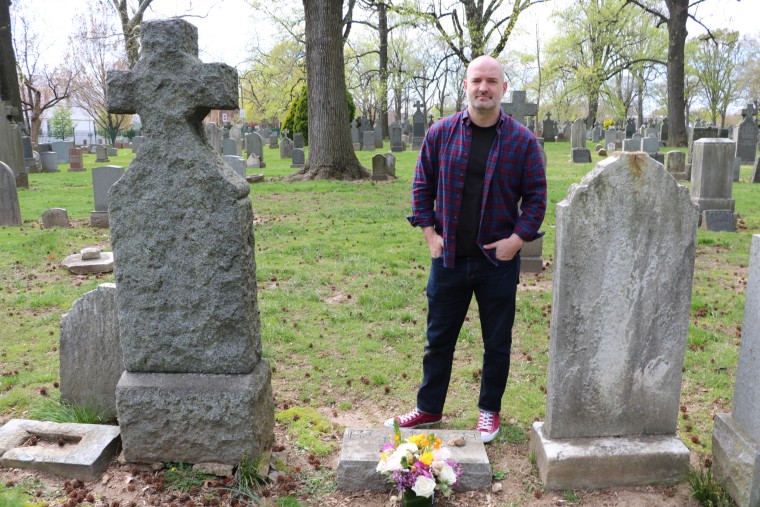Crawford poses at his mother's grave site.