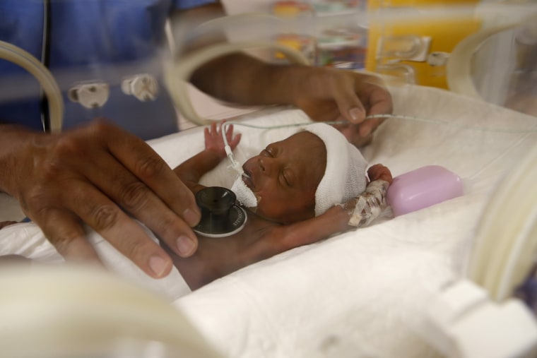 Dr. Msayif Khali examines one of the nine babies of Halima Cisse, 25, in Casablanca, Morocco on May 20, 2021.