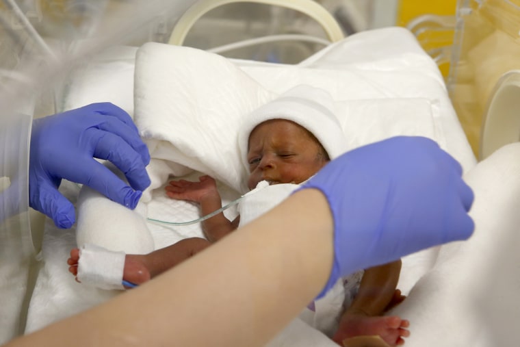 A nurse at the Casablanca Ain Borja Clinic in Morocco cares for one of nine babies born in a set of nonuplets in 2021. 