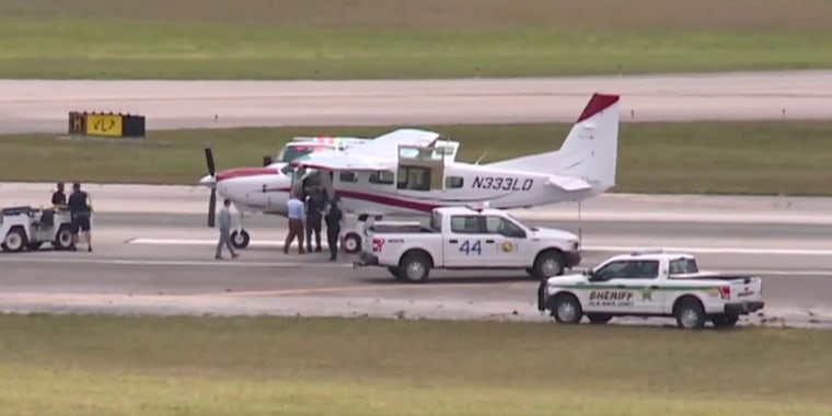 A small aircraft stands on the runway at Palm Beach International Airport.