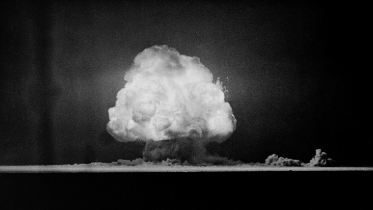 Una nube de hongo crece por sobre un terreno arenoso y desértico en Nuevo México en 1945, cuando fue realizada la prueba atómica Trinity, la primera prueba nuclear en el mundo.