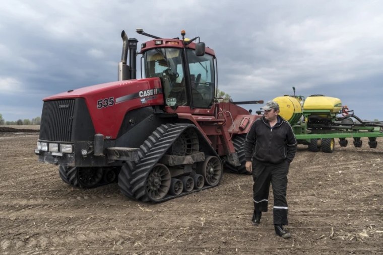 Vyacheslav, a tractor driver for AgroRegion, walks near his tractor in a field he is planting with corn on April 25, 2022 near Boryspil, Ukraine.