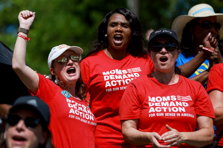 Tanya Reid, Miguelaille Pierre, and Cristina Rodrigues attend a vigil, organized by Moms Demand Action, for victims of recent mass shootings on May 28, 2022, in Sunrise, Fla.