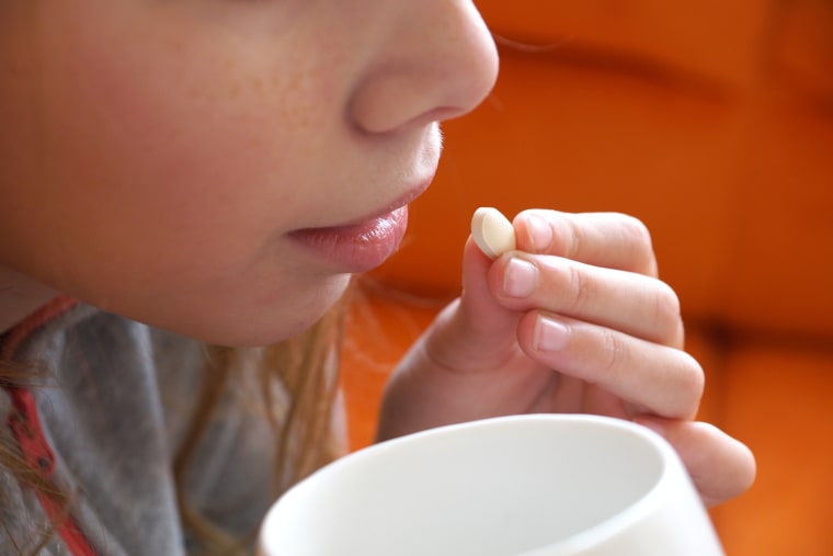 a girl takes a pill close up