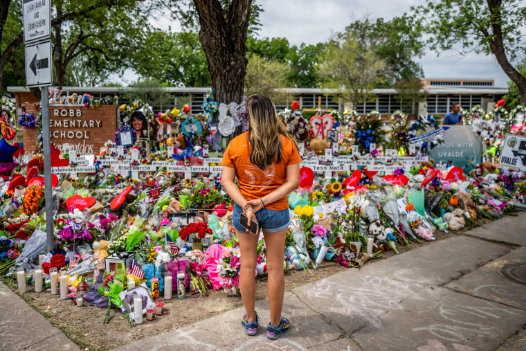 A Uvalde resident pays her respects on May 31, 2022, at a memorial dedicated to the 19 children and two adults killed in the mass shooting at Robb Elementary School in Uvalde, Texas.