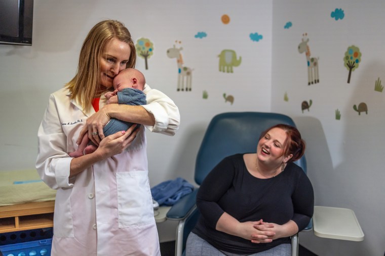 Dr. Leanne Redman, director of the Maternal and Child Research Laboratory at Pennington Biomedical Research Center, holds Julie Hardy's son, Jameson, right, on May 12, 2022 at Louisiana State University's Pennington Biomedical Research Center in Baton Rouge.
