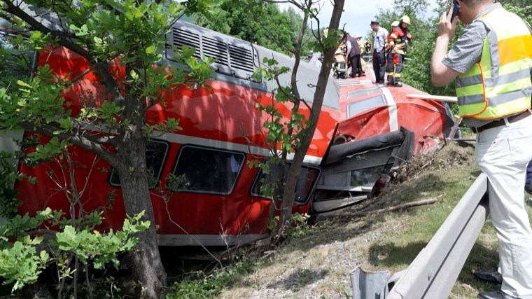 Firemen and rescue helpers work around a derailed train
