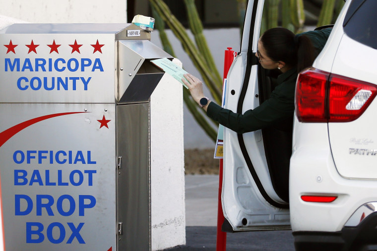 A voter drops off a ballot for the Arizona Democratic presidential preference election, in Phoenix, on March 17, 2020.