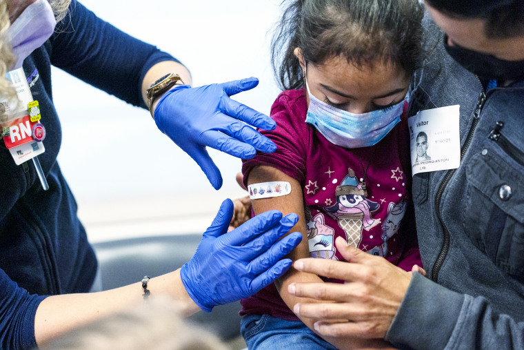 Kidney transplant patient Sophia Silvaamaya, 5, held by her father Pedro Silvaamaya, gets a bandaid on her arm after getting vaccinated for Covid-19 on Nov. 3, 2021, at Children's National Hospital in Washington.