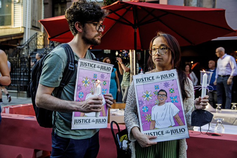 People hold signs commemorating Julio Ramirez during a vigil in New York, in 2022