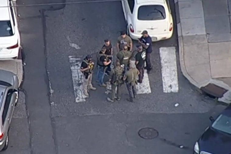 Police gather near the scene of a shooting in Philadelphia on Monday.