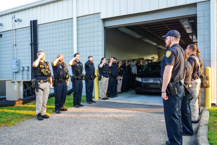 Tallahassee police officers salute a fallen officer who died after a car incident with a suspect on June 8, 2022.