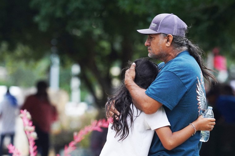 Families hug outside the SSGT Willie de Leon Civic Center