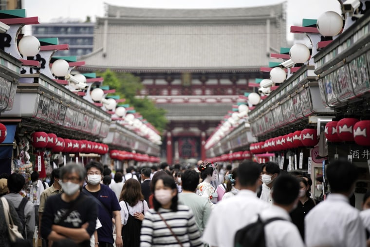 Tourists and shoppers walk the streets of Tokyo's Asakusa district on Friday. 