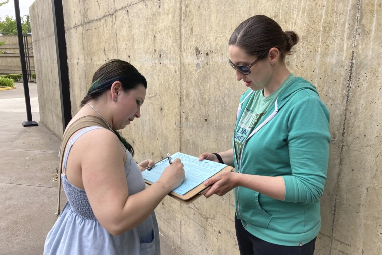 A woman signs an initiative petition supporting a gun-safety ballot measure