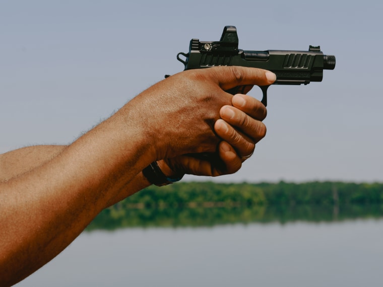 Philip Smith holds a handgun.