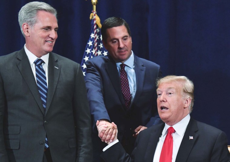 Former President Donald Trump shakes hands with Devin Nunes as Rep. Kevin McCarthy looks on during a meeting in Scottsdale, Ariz. on October 19, 2018.