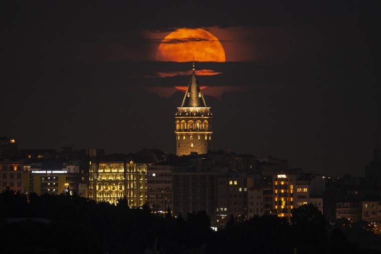 A supermoon rises behind the Galata Tower in Istanbul, Turkey.