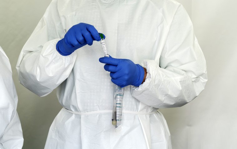 Image:   A Laboratory technician holds a bag with antibody and swab tests tubes for Covid-19 at SOMOS Community Care site in the Washington Heights neighborhood of New York City on May 22, 2020.