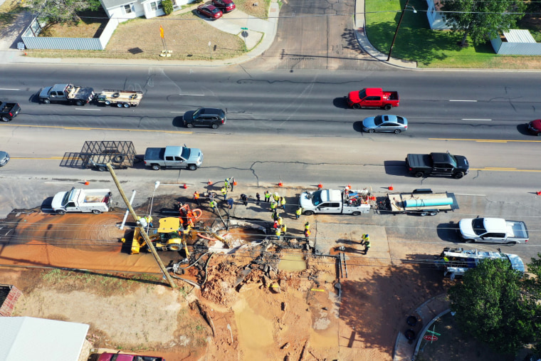 Crews repair the break underneath the  intersection of 42nd and San Jacinto Streets in Odessa, Texas, on June 14, 2022.