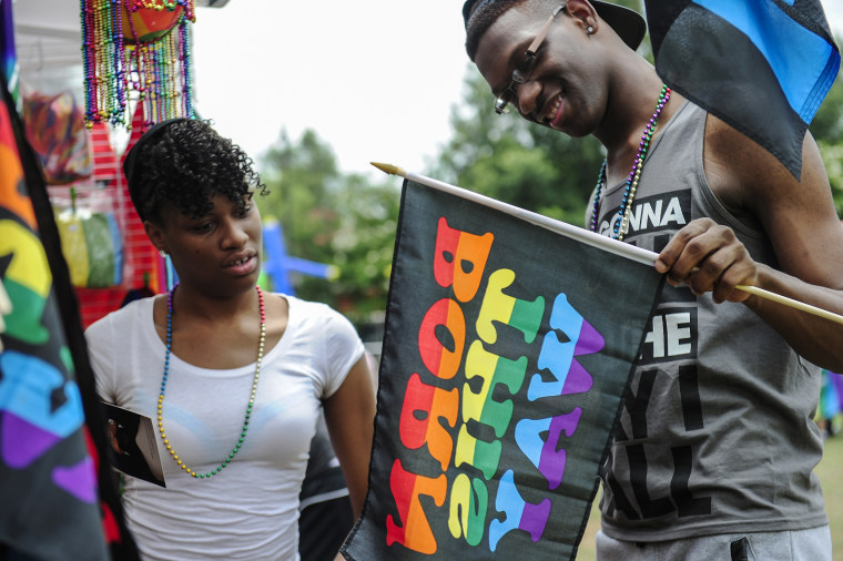 Participants look at a Born This Way sign as they browse a booth selling Pride items during the Pride Festival at the Augusta Commons on June 28, 2014, in Augusta, Ga.